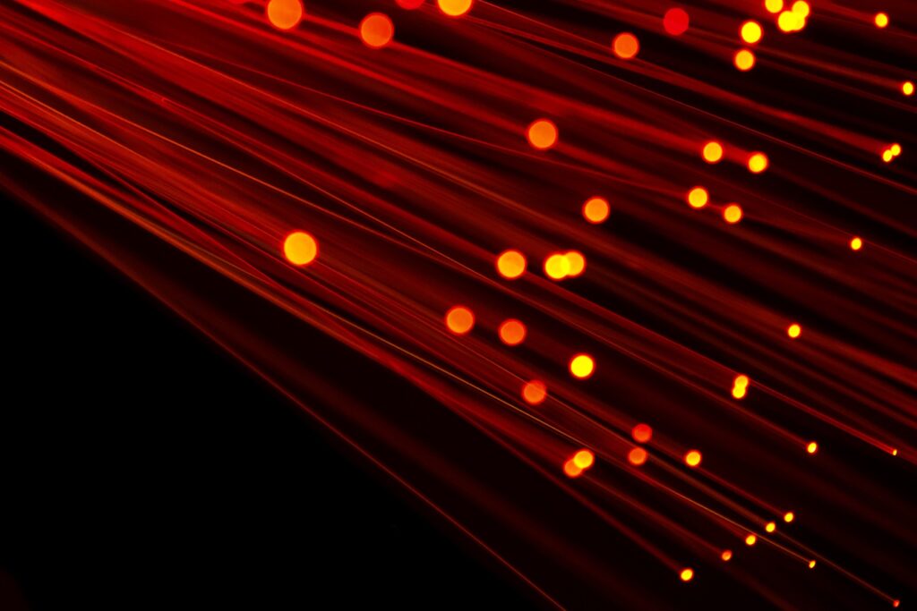 How To Get NBN Connected In Your Home 2 Fiber optic light image with red hue on black background. Ideal image to depict broadband, technology, speed and cable infrastructure