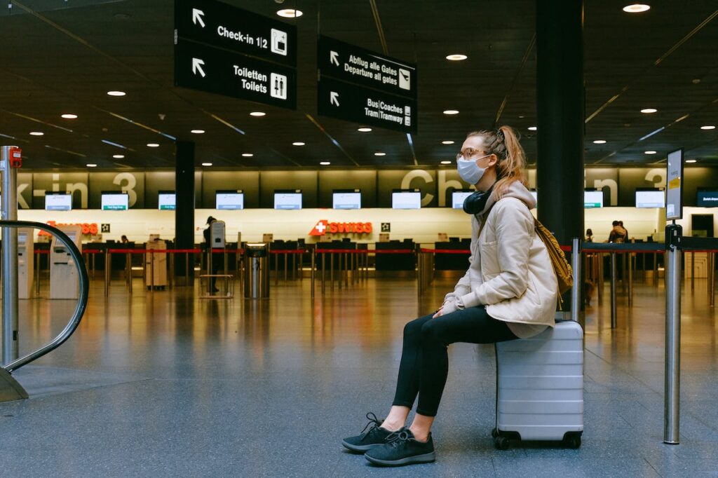 BudgetAir.com Review: Is It Legit Or A Scam? 2 Woman sitting on a luggage.