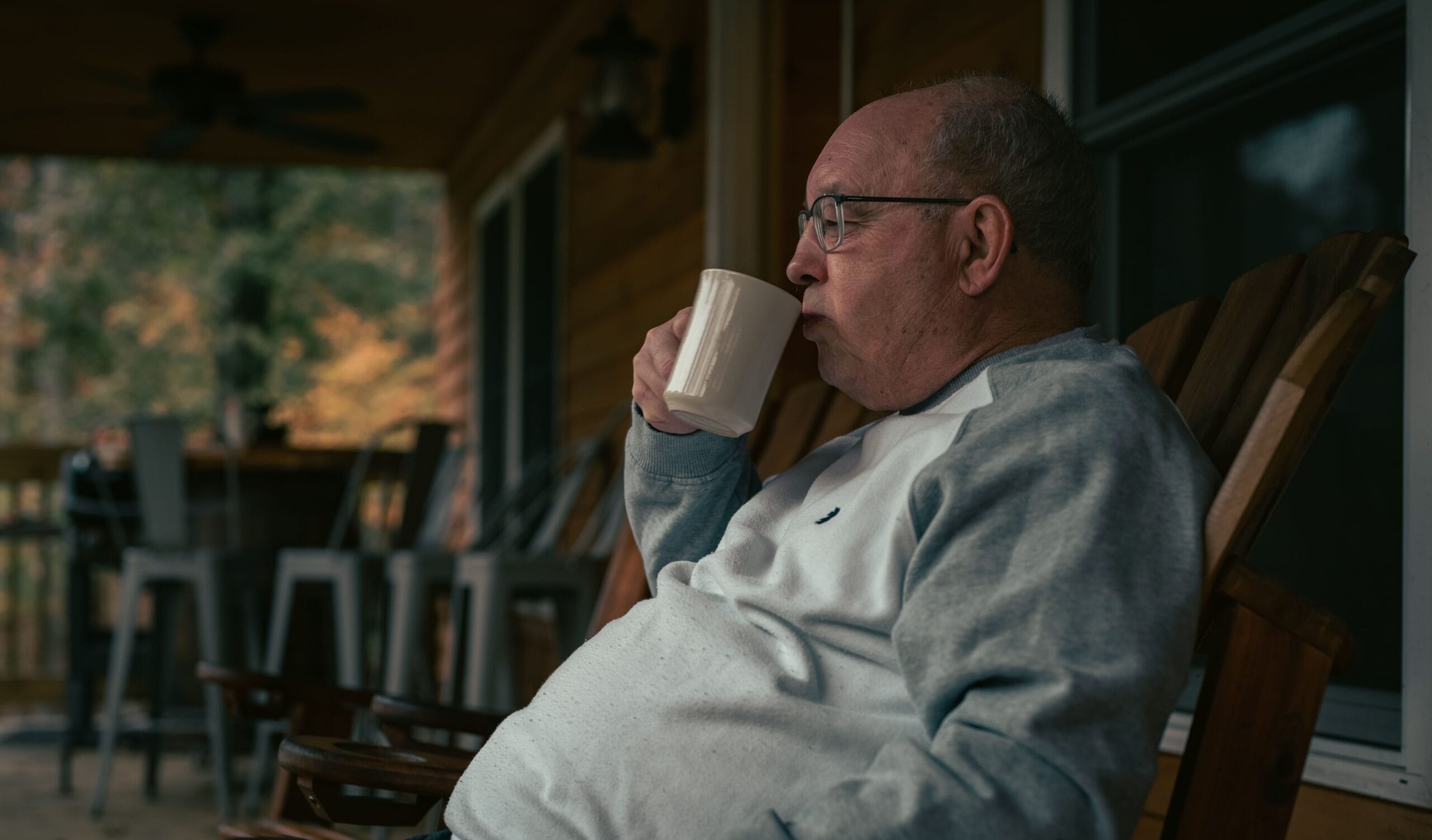 thoughtful investor looking at a chart with a coffee mug on a porch