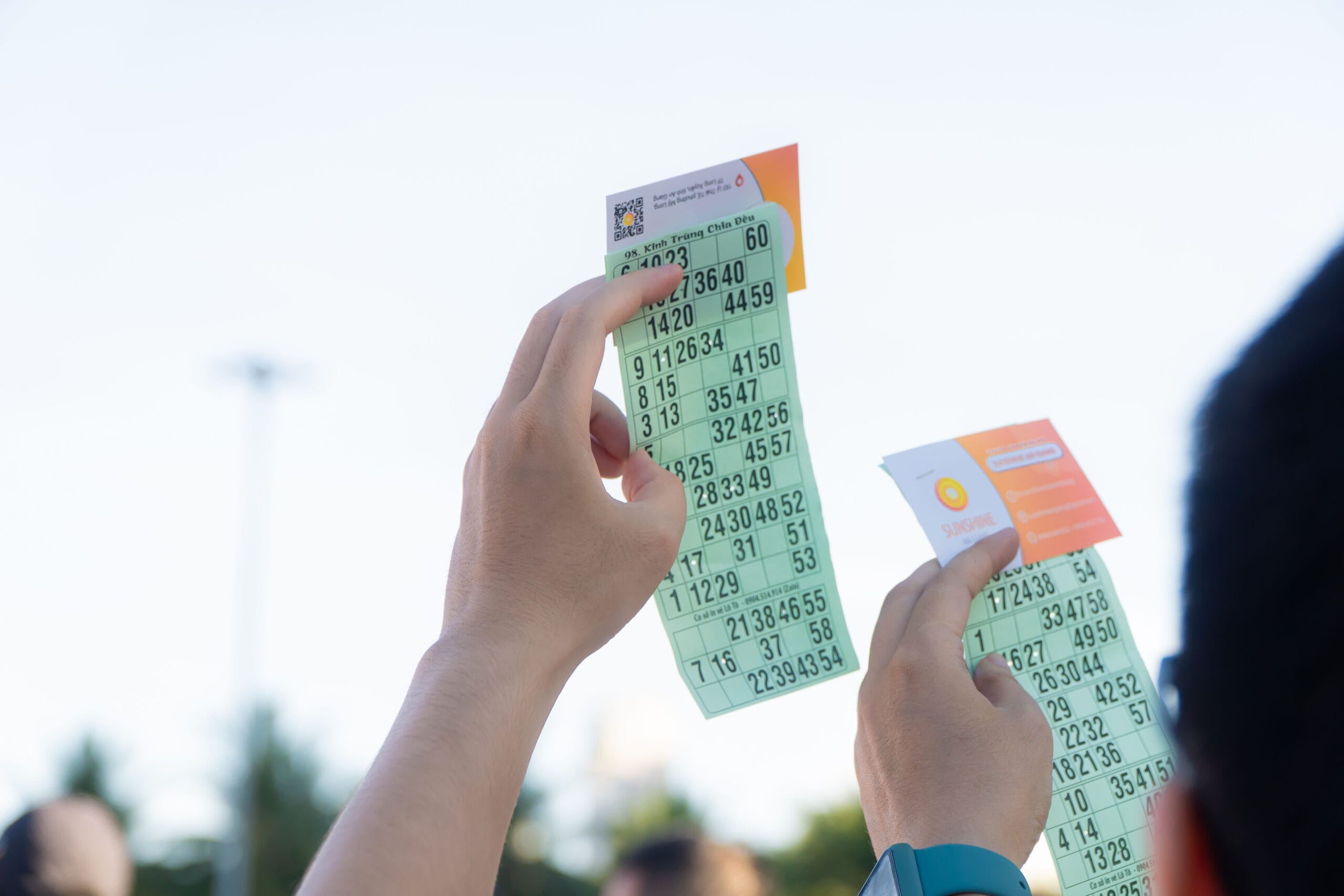NJ Lottery Payouts: Real Money or Hype for Side Hustlers? 2 A hand holding a colorful lottery ticket next to a smartphone with gig‑economy apps open