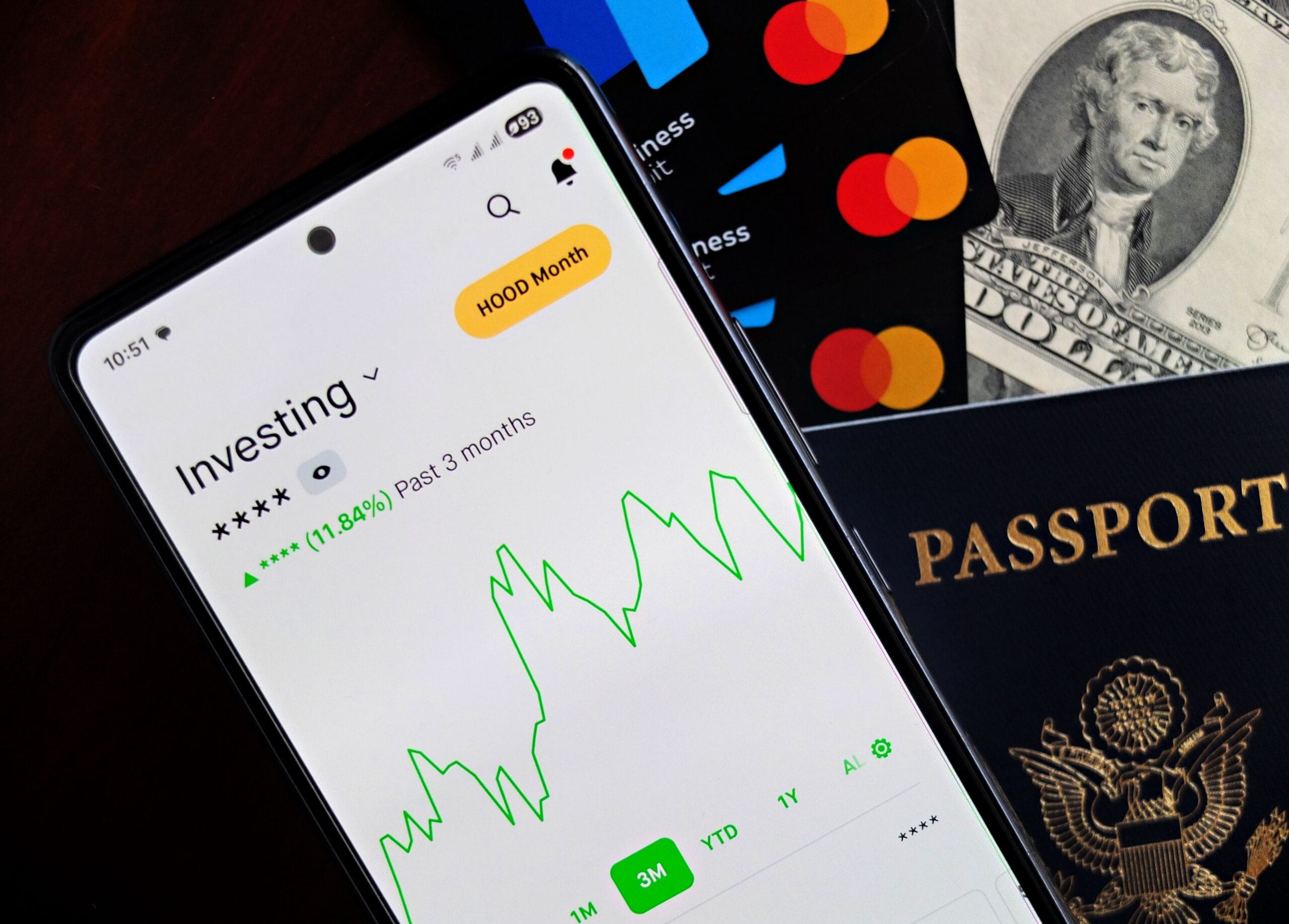 young investor holding a smartphone showing a diversified stock portfolio app