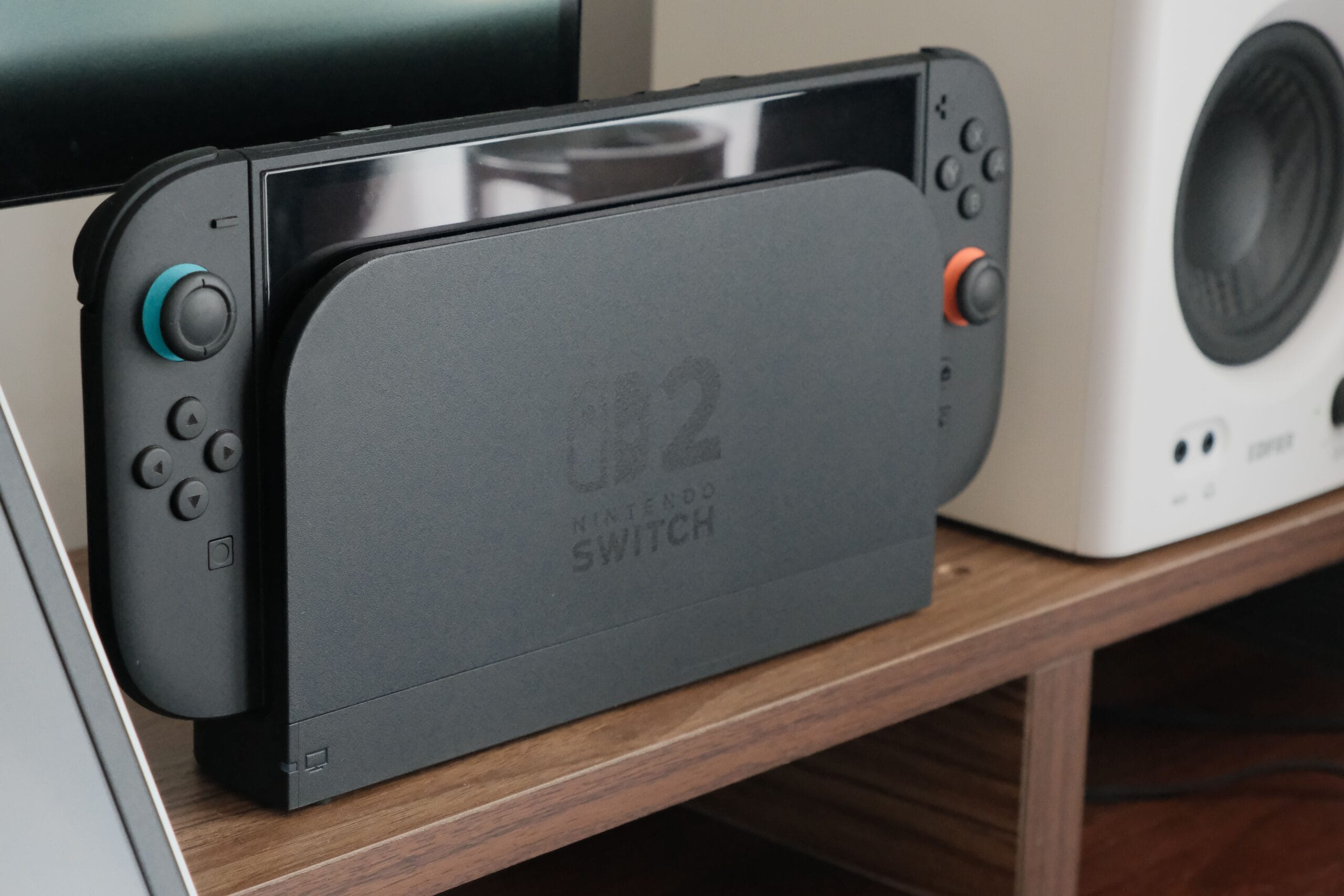 Is Nintendo Stock a Safe Bet for Side Hustlers? 2 A bright Nintendo Switch console on a wooden desk with a coffee mug and laptop