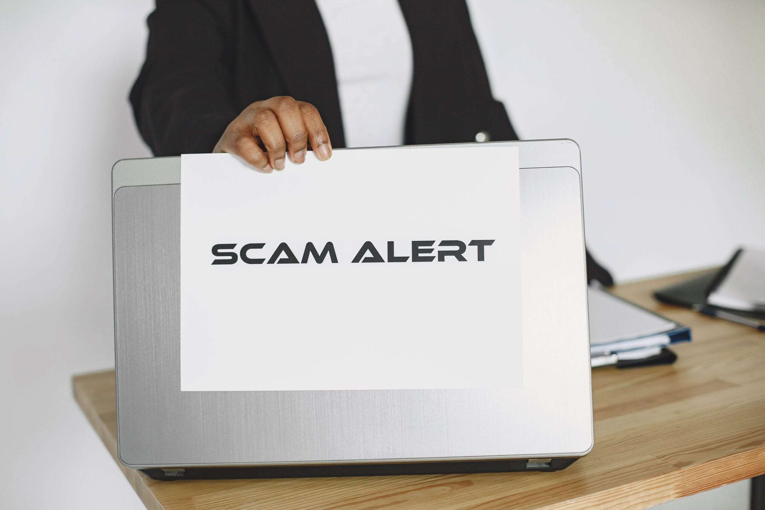 Legit Survey Sites That Pay Instantly via PayPal 6 a person reviewing a laptop screen with a checklist of scam warnings