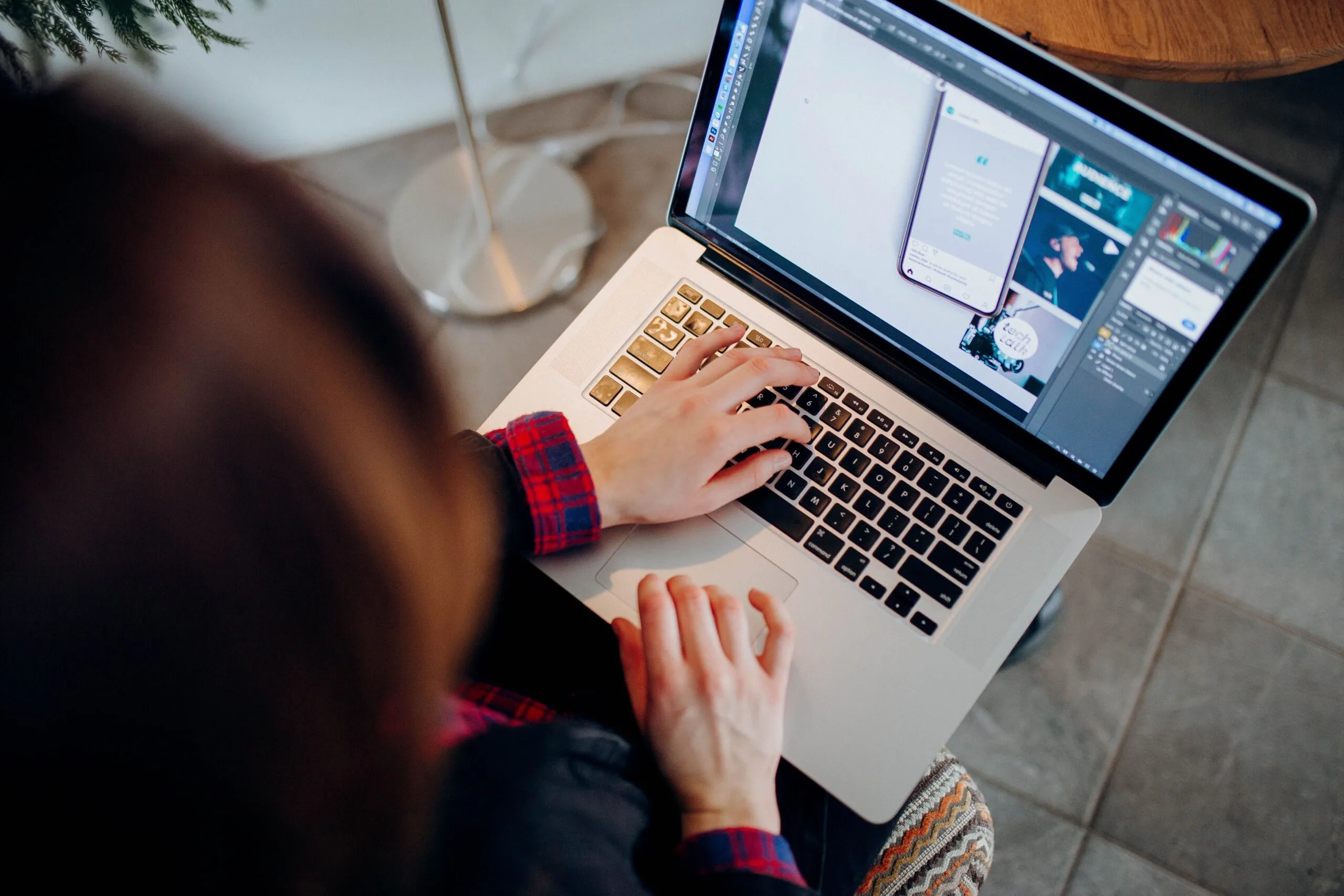 A freelancer checking a laptop screen with financial graphs while sipping coffee