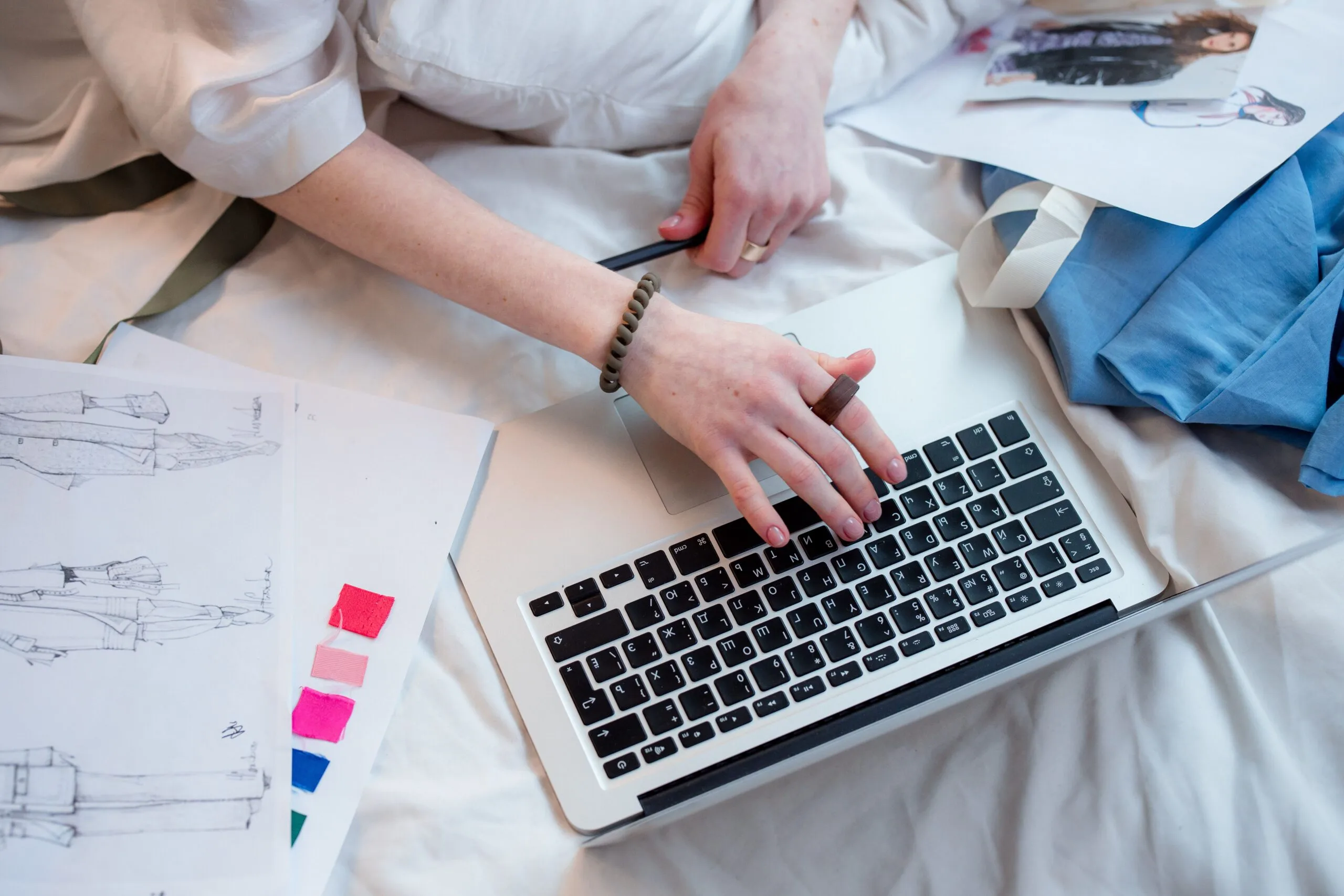 Freelancer designing a website on a tablet while economic charts appear in the background