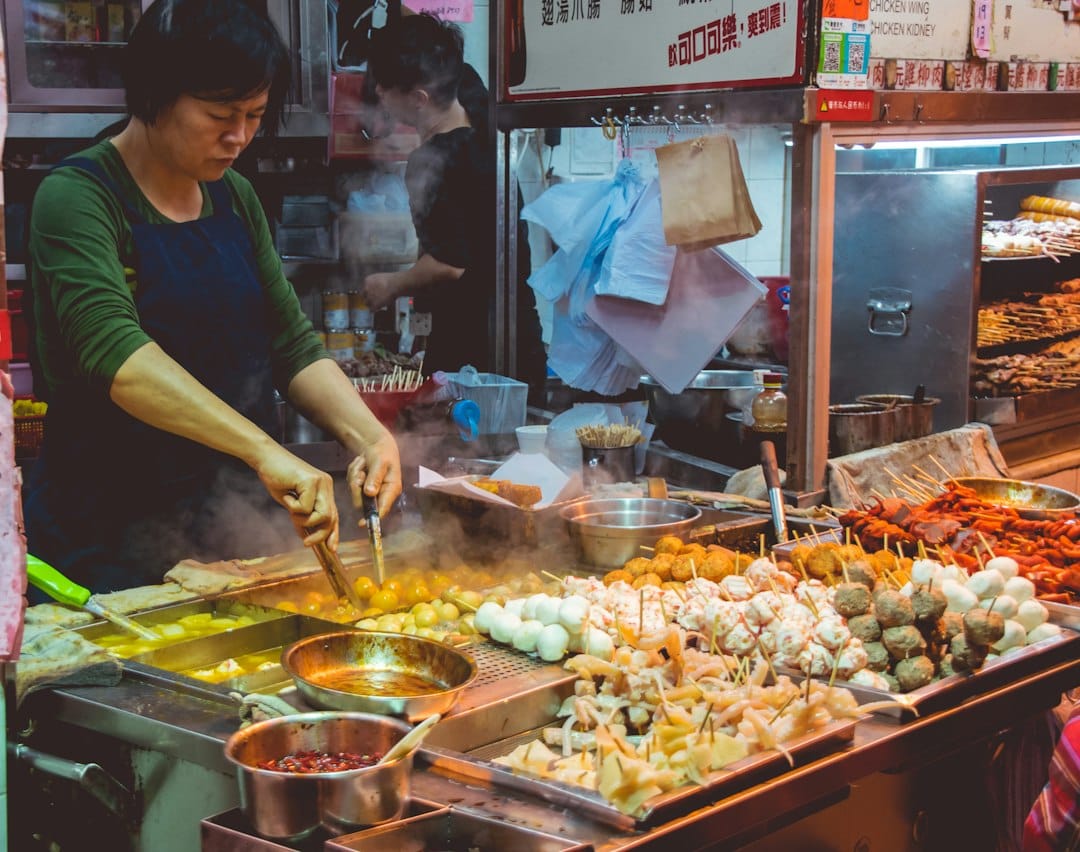Budget travel: A Practical Guide 5 A bustling street market with colorful stalls selling fresh fruit, grilled meat, and local snacks
