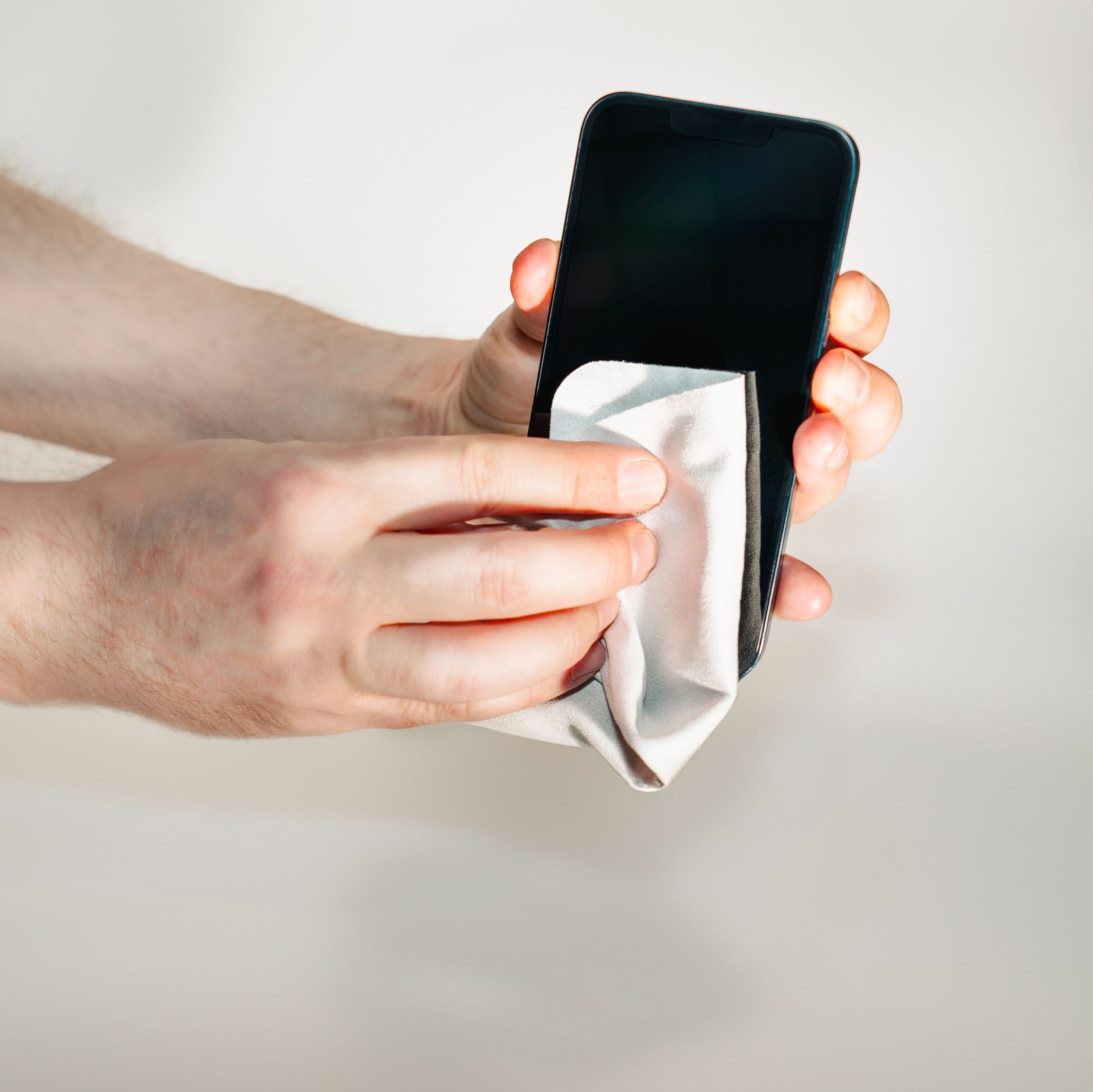 Where to Sell Old Electronics for Cash: Best Places & Tips 4 close‑up of a smartphone being wiped with a microfiber cloth