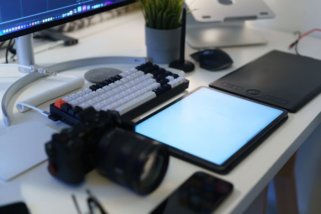Freelancing: What It Is, How to Start, Jobs, Rates & Tips (2026) 4 A designer sketching on a tablet while a laptop displays a branding mockup, illustrating creative freelance work