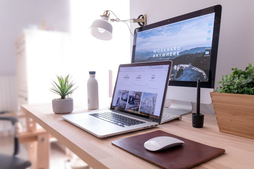 A bright home office with a laptop, coffee mug, and notebook